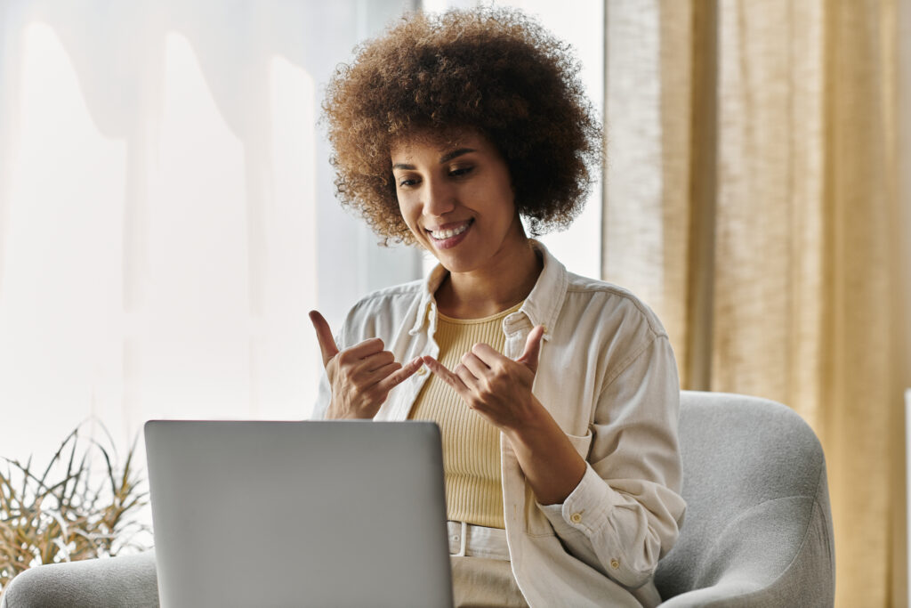Woman signing to her computer via Video Remote Interpreting